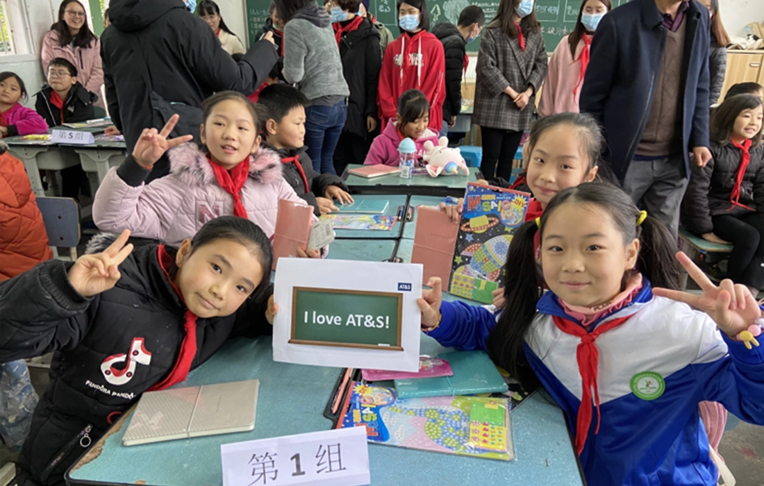 Mitarbeiter:innen von AT&S in Chongqing überreichen sozial benachteiligten Schüler:innen Computer, Wintermäntel und Spiele.